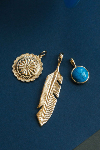 oversized gold feather pendant with concho shell and turquoise gemstone charms	