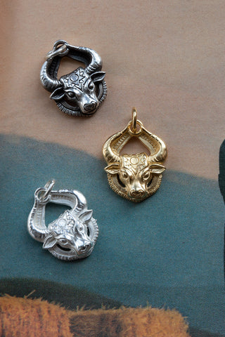 antique silver shiny silver and 14kt gold bull pendants	